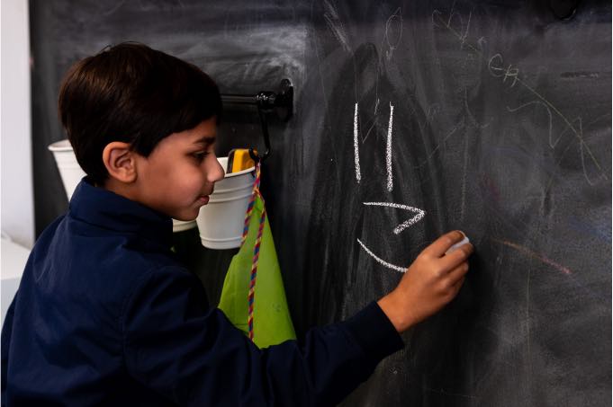 Child drawing on chalkboard during Speech Pathology at Voice Within Therapy Centre