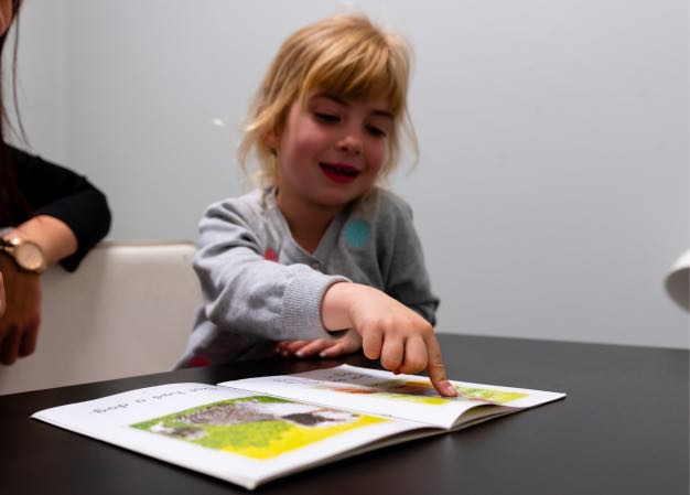 Child reading a book during Speech Therapy at Voice Within Therapy Centre