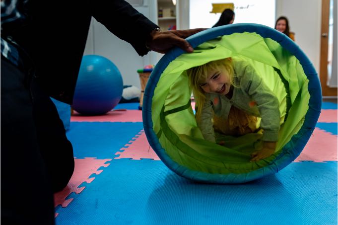 Child crawling through play tunnel during Speech Therapy at Voice Within Therapy Centre