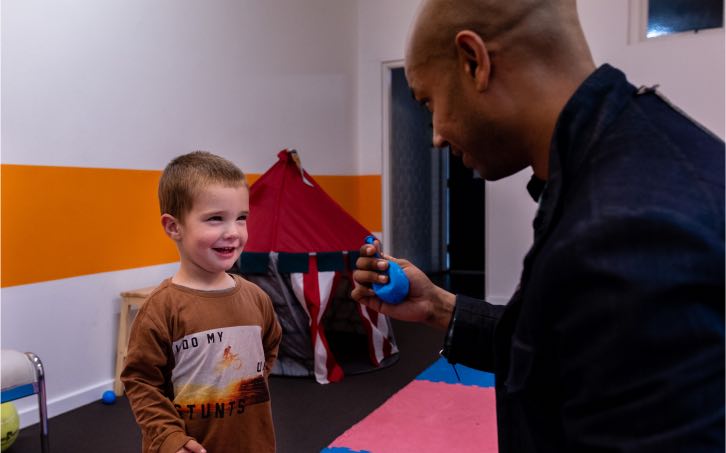 Speech Therapist showing a balloon to a young boy in Speech Therapy at Voice Within Therapy Centre