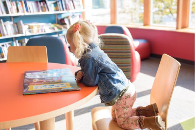 Pre-School girl reading a book by herself